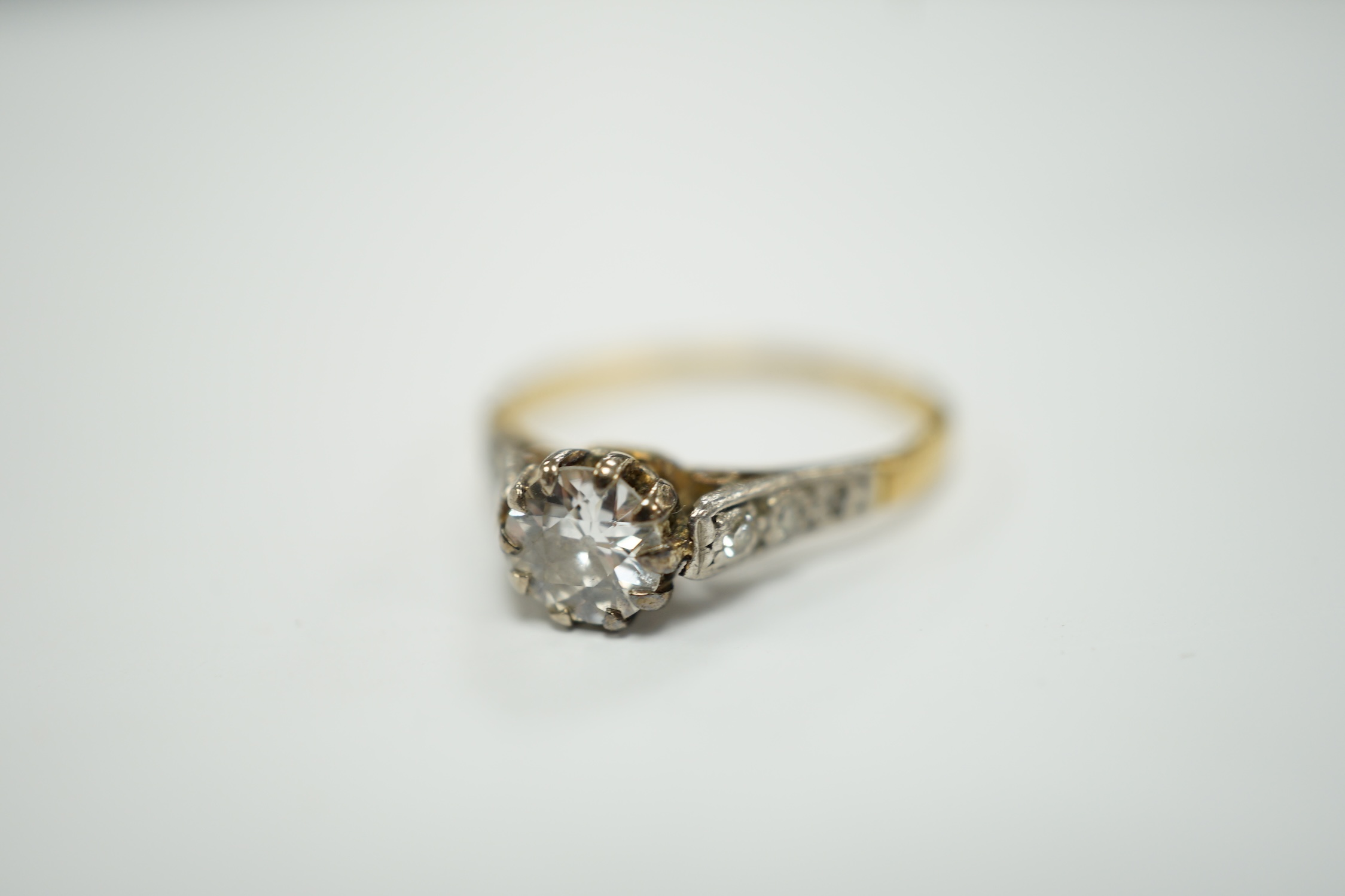 An 18ct, plat and single stone diamond set ring, with diamond chip set shoulders